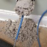 Dryer lint being removed from vent duct with rotary brush tool